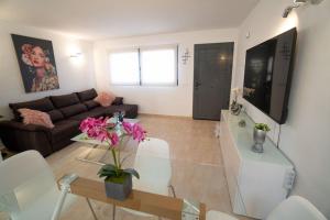 ein Wohnzimmer mit einem Sofa und einem Tisch in der Unterkunft Casa Alfred, El Cotillo, Best one beach to 150 m WIFI fiber in Cotillo