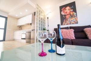 una mesa de cristal con una botella de vino y dos copas de vino en Casa Alfred, El Cotillo, Best one beach to 150 m WIFI fiber en El Cotillo