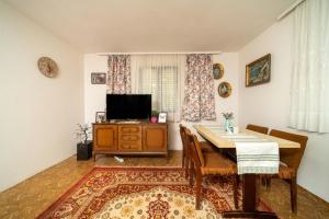 ein Wohnzimmer mit einem Esstisch und einem TV in der Unterkunft Baba's House in Raška