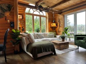 a living room with a couch and a table at Le Ti Moose - Les Chalets Spa Canada in La Malbaie