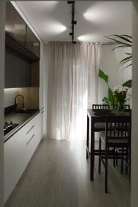 a kitchen with a table and chairs and a window at RomanApartments in Mestre
