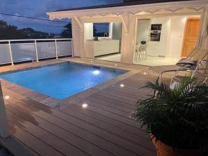 a swimming pool on the deck of a house at Les Appart villa Sunbay Caraibes avec piscine privative vue mer et montagne in Le François
