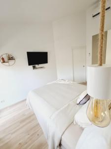 a white room with a bed and a tv at INFINITY VIEW in Playa del Aguila