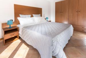 リミニにあるResidence Del Soleのベッドルーム(白い大型ベッド1台、木製キャビネット付)