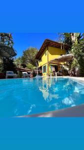 a large blue swimming pool in front of a house at Pousada Estalagem Paraty in Paraty