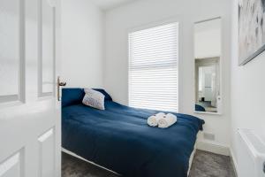 a bedroom with a blue bed with towels on it at Dacy Lodge - Anfield Apartments in Liverpool
