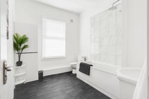 a white bathroom with a toilet and a sink at Dacy Lodge - Anfield Apartments in Liverpool