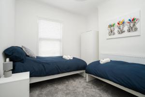 1 dormitorio con 2 camas y ventana en Dacy Lodge - Anfield Apartments en Liverpool