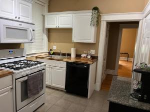 a kitchen with white cabinets and a stove top oven at Flat at Forest Park - Walk or Bike to Zoo! in Benton