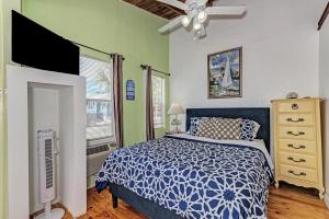 a bedroom with a blue and white bed and a fan at Playa Esmeralda Studios in Bradenton Beach