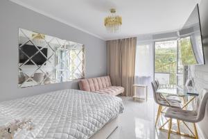 - une chambre avec un lit, une chaise et une table dans l'établissement Gold Glamour Apartment Sopot z dwoma sypialniami, duzy balkon, à Sopot