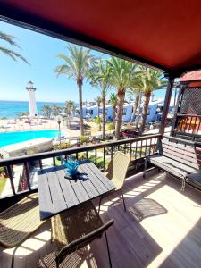 um pátio com uma mesa e cadeiras e o oceano em INFINITY VIEW em Playa del Aguila