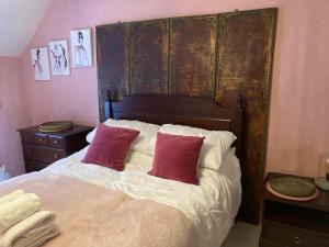 a bedroom with a bed with two red pillows at 4 Cumberland Cottages in Kingsbridge