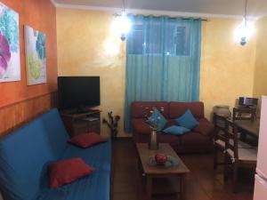 ein Wohnzimmer mit einem Sofa und einem TV in der Unterkunft Casa Rural El Patio Agulo in Agulo