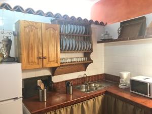 una cocina con armarios de madera y fregadero en Casa Rural El Patio Agulo, en Agulo