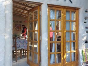 un hombre está sentado en una mesa en una habitación con puertas en ECO-LOFT, Sombra de Chañar,- Mallín Córdoba in 