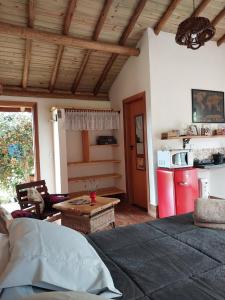 Il comprend un salon avec un réfrigérateur rouge et une cuisine. dans l'établissement Chalé Canto Mundo, à Brazópolis