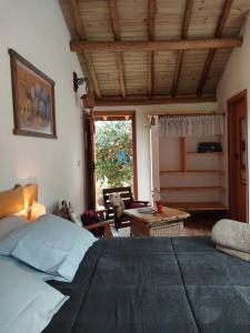 une chambre avec un grand lit et un salon dans l'établissement Chalé Canto Mundo, à Brazópolis