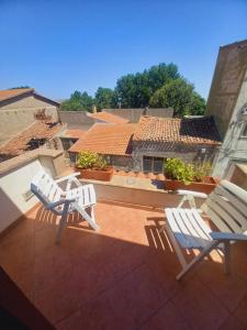 2 Stühle auf einer Terrasse mit einem Haus in der Unterkunft La casa delle fate in Giave