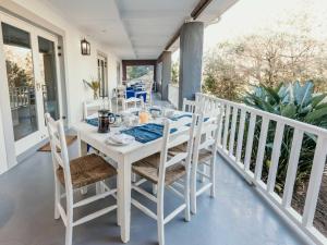 una mesa de comedor blanca y sillas en un porche en SchoemansRus, en Riebeek-Wes