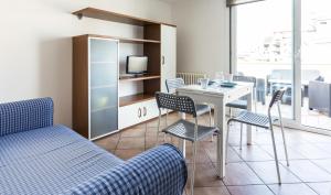 - un salon avec un lit, une table et des chaises dans l'établissement Residence Del Sole, à Rimini