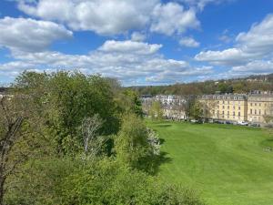 a green field in front of a large building at Crescent Penthouse with Stunning Views and free parking in Bath