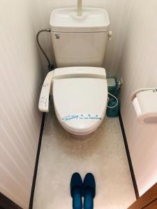 a bathroom with a toilet with blue shoes on the floor at City Inn Kokura - Vacation STAY 12140 in Kitakyushu