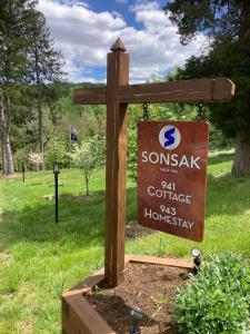 ein Holzschild für einen Garten mit einem Schild für ein Someoneak Cottage in der Unterkunft Sonsak - Unit 3 in Charlottesville