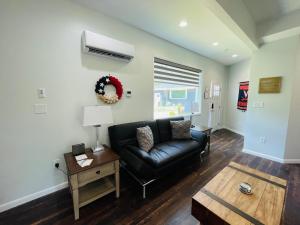 uma sala de estar com um sofá de couro preto e uma mesa em Sonsak - Unit 3 em Charlottesville