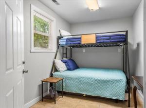 a bedroom with a bunk bed with blue pillows at Modern Comforts, Classic Charm: Neighborhood Gem in Richmond