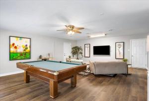 a living room with a pool table and a ceiling fan at Modern Comforts, Classic Charm: Neighborhood Gem in Richmond