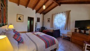 1 dormitorio con 1 cama y TV de pantalla plana en Copacabaña Lodge, en Chancos