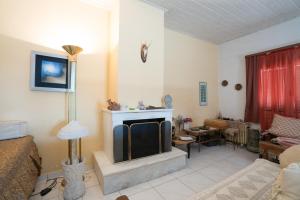 a living room with a fireplace and a tv at Greek Village house Peloponnese Sea&Mountain in Aigio