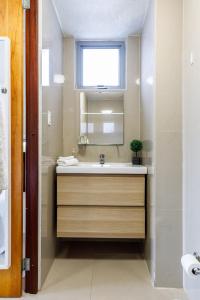 baño con lavabo y ventana en Avila Suites, en San Juan
