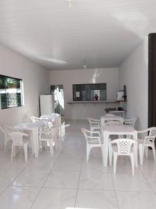 uma sala de jantar com mesas e cadeiras brancas em Pousada JF tour em Ponte Alta do Tocantins