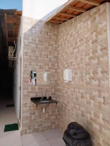 uma casa de banho com um lavatório numa parede de pedra em Pousada JF tour em Ponte Alta do Tocantins