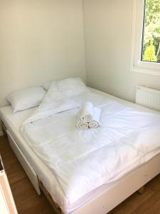 białe łóżko z ręcznikami na górze w obiekcie Bungalow Camping Jacuzzi & Sauna w Solinie