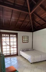 卡貝德盧的住宿－CASA CAMPESTRE COM PISCINA，一间带一张床的卧室,位于带木制天花板的房间内