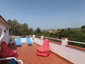 a balcony with blue chairs and red cushions on it at Casa vacacional en plena naturaleza in Pacs del Penedes