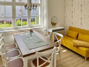 sala de estar con mesa y sofá amarillo en FeWo Art Deco, en Zittau