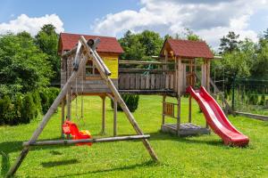 um parque infantil com escorrega e uma casa de brincar em Noclegi Na Brzegu em Szaflary