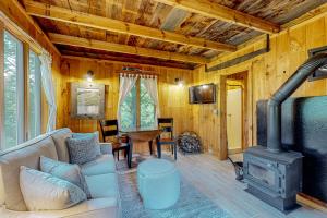 a living room with a couch and a wood stove at Spruce Moose Cottage in Hartland