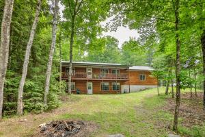 uma cabana de madeira com um deque na floresta em Turtle Flambeau Flowage Retreat em Mercer