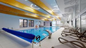 a swimming pool with a slide in a building at Apartament Dominikana 13 in Sianozety