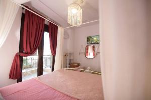 a bedroom with a pink bed and a window at AMALFI luxury APARTMENT in Komotini