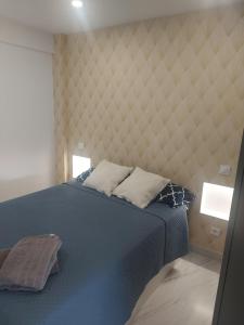 1 dormitorio con 1 cama azul y 2 almohadas en Apartamento JARDIN DELUZ, con Wifi y Parking privado gratis, en Santander