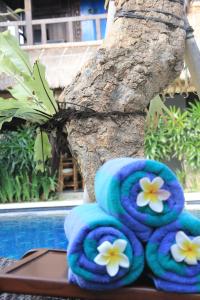 ein Haufen blauer Handtücher mit weißen Blumen drauf in der Unterkunft Radiant Jepun Villa in Legian