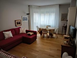 - un salon avec un canapé rouge et une table dans l'établissement Appartamento Isa, à Tarvisio