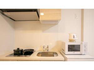 uma cozinha com um lavatório e um micro-ondas em ESLEAD HOTEL Namba Daikokucho - Vacation STAY 86023v em Osaka