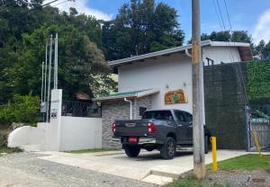 Ein schwarzer Truck parkt vor einem Haus. in der Unterkunft Villas Flakis, Luna in Monteverde Costa Rica